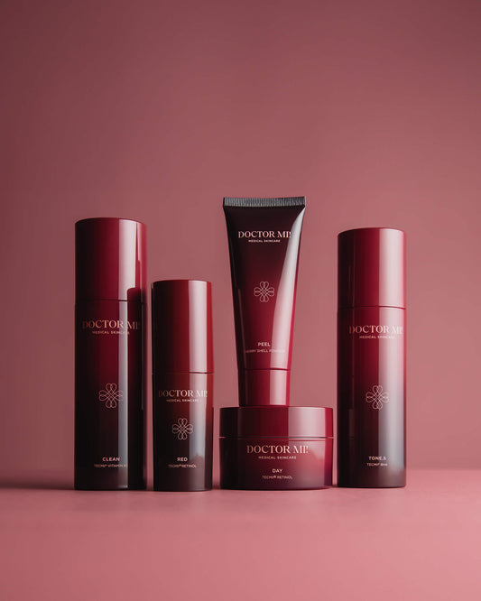 DOCTOR MI! AKNE SET Produktset für zu Akne neigender Haut mit tiefenwirksame und beruhigende Prozesse für ein klares Hautbild dank TECMi!® Retinol mit BALANCING CLEANSER in rotem Pumpspender, REVIVING PEEL in roter Tube, RENEWING TONER in rotem Pumpspender, REFINING DAY CREAM in rotem Tiegel,  RED BOOSTER in rotem Pumpspender auf rotem Hintergrund