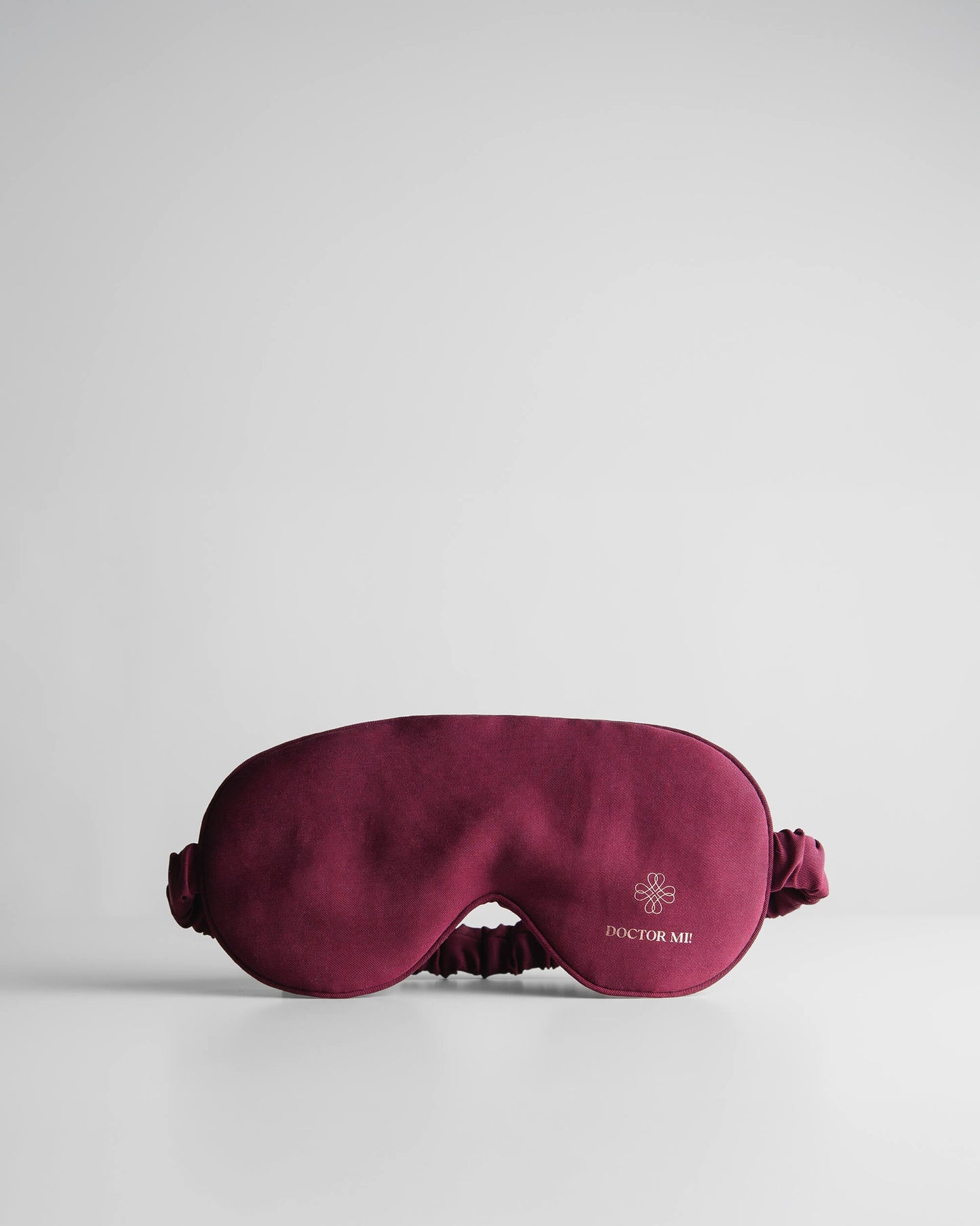 DOCTOR MI! SLEEP MASK hochwertige Schlafmaske für erholsame Nächte als praktischer Reisebegleiter in rotem Material auf grauem Hintergrund