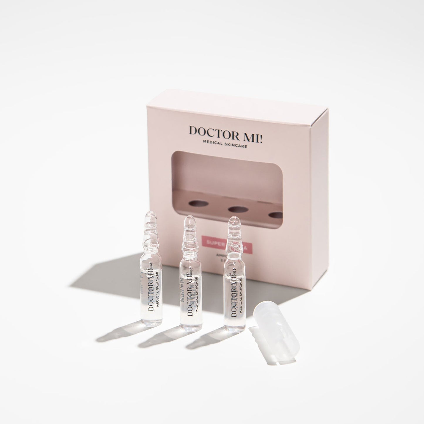 DOCTOR MI! SUPER HYDRA AMPOULES intensive Feuchtigkeit Ampullen für eine starke Hautbarriere und intensive Pflege in weißer Verpackung mit Glasampullen auf grauem Hintergrund 