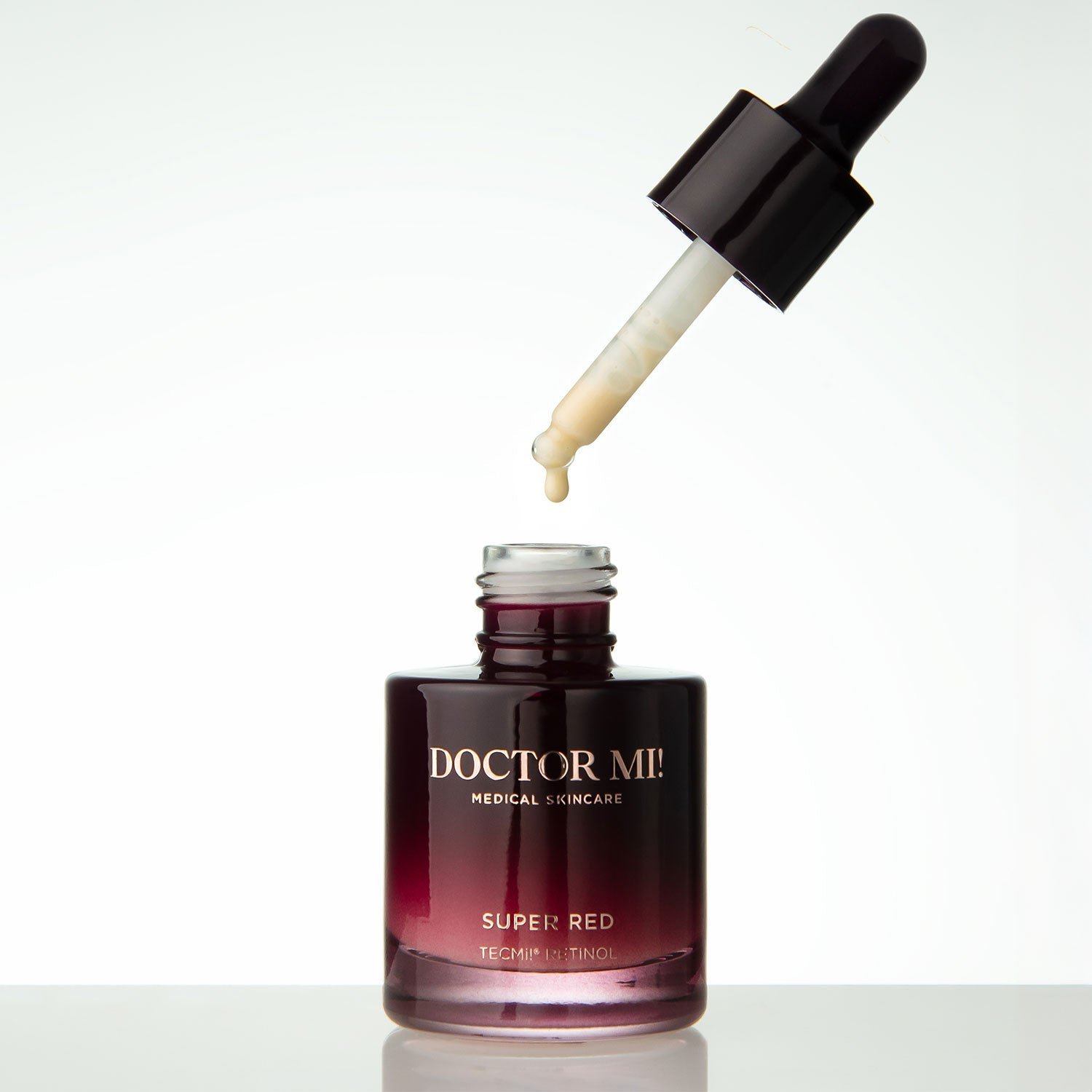 DOCTOR MI! SUPER RED SERUM overnight refining treatment Serum mit Retinol TECMi!® Technologie mit offenem rotem Glasflakon und Pipette mit dickflüssiger hochwirksamer Textur auf weißem Hintergrund